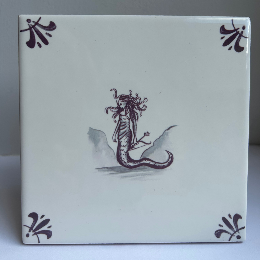 A square ceramic tile with a white glaze, featuring a central illustration of Medusa in manganese, surrounded by matching decorative corner motifs.