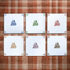 Six square tiles in blue, green, crimson, mustard, manganese, sepia with an illustration of William Shakespeare on a tartan background.