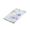 A notebook with a white and blue flora and fauna pattern with metal corner tips, shown at an angle on a solid white background.